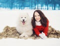 Happy woman having fun with white Samoyed dog outdoors on the snow in winter day Royalty Free Stock Photo