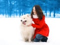 Happy woman having fun with white Samoyed dog outdoors in winter Royalty Free Stock Photo