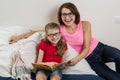 Happy woman with her daughter child, reading together a book a Royalty Free Stock Photo