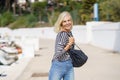 Happy woman in her 60s strolling along a seaside spot near the beach. Royalty Free Stock Photo