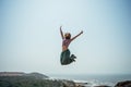 Happy woman high jumping of joy on beach in a casual wear Royalty Free Stock Photo