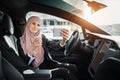 Lady sitting in electric car and having video call on mobile Royalty Free Stock Photo