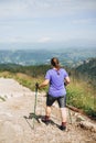 Happy woman hiker with backpack standing on the slope of mountain ridge against mountains. 30s Women holding hiking Royalty Free Stock Photo