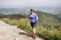 Happy woman hiker with backpack standing on the slope of mountain ridge against mountains. 30s Women holding hiking Royalty Free Stock Photo