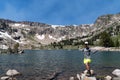 Happy woman hiker stands on the shores of Lake Solitude in Grand Teton National Park Royalty Free Stock Photo