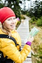 Happy woman hiking and reading map in forest Royalty Free Stock Photo