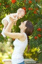 Happy woman holding in arm a baby in a garden Royalty Free Stock Photo