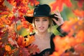 Happy woman holding autumn leafs on face in fall nature. Portrait of young woman with autumn maple leaves outdoor Royalty Free Stock Photo