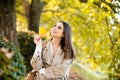 Happy woman holding autumn leafs on face in fall nature. Portrait of young woman with autumn maple leaves outdoor Royalty Free Stock Photo