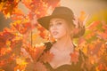 Happy woman holding autumn leafs on face in fall nature. Portrait of young woman with autumn maple leaves outdoor Royalty Free Stock Photo