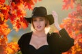 Happy woman holding autumn leafs on face in fall nature. Portrait of young woman with autumn maple leaves outdoor Royalty Free Stock Photo