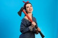 The happy woman holding the axe on the blue background. Royalty Free Stock Photo