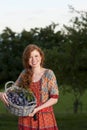 Happy woman holding a basket with plums Royalty Free Stock Photo