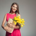 Young happy woman holding basket with yellow tulips. Royalty Free Stock Photo