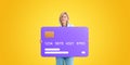 Happy woman holding big credit card