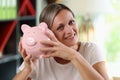 Happy woman holding big piggy bank in her hands and looking at camera close-up. Royalty Free Stock Photo