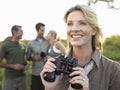 Happy Woman Holding Binoculars With Friends In Background Royalty Free Stock Photo