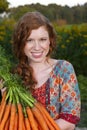 Happy woman holding a bunch of carrots Royalty Free Stock Photo