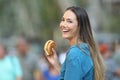 Happy woman holding a burger looking at you Royalty Free Stock Photo