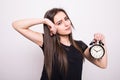 Happy woman holding clock against a grey Royalty Free Stock Photo