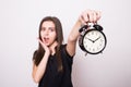 Happy woman holding clock against a grey Royalty Free Stock Photo