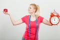 Happy woman holding clock, apple and measuring tape Royalty Free Stock Photo