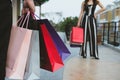 Happy woman holding colorful shopping bag outdoors. shopaholic m