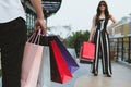 Happy woman holding colorful shopping bag outdoors. shopaholic m