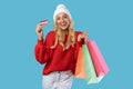 Happy woman holding credit card carrying shopping bags in winter Royalty Free Stock Photo