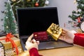 Happy woman holding credit card doing online shopping present at Christmas. Mockup laptop computer with white screen Royalty Free Stock Photo