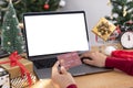 Happy woman holding credit card doing online shopping present at Christmas. Mockup laptop computer with white screen Royalty Free Stock Photo