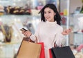 Happy woman holding credit card and shopping bag at mall Royalty Free Stock Photo