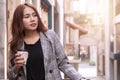 Happy woman holding a cup of coffee in her hands relaxing at outdoor with copy space. Attractive cheerful girl enjoying hot Royalty Free Stock Photo