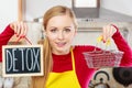 Happy woman holding detox sign and shopping basket