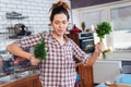 Happy woman holding dill and dacing on the kitchen