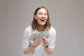 Happy woman holding dollars on gray background Royalty Free Stock Photo