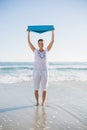 Happy woman holding exercise mat over her head Royalty Free Stock Photo