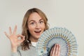 Happy woman holding fan of us dollars money showing ok sign on white background. Happy girl hand okay symbol Royalty Free Stock Photo
