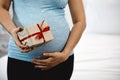 Happy Woman Holding a Gift Box with Love and Anticipation in Her Bedroom with copy space