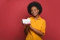 Happy woman holding gift box and smiling on red background Royalty Free Stock Photo