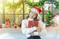 Happy woman holding gift boxes with Merry Christmas decoration in window background Royalty Free Stock Photo