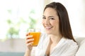 Woman holding a glass of orange juice at home Royalty Free Stock Photo