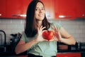 Happy Woman Holding a Heart Shaped Tomato in the Kitchen Royalty Free Stock Photo