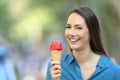 Happy woman holding an ice cream looking at you Royalty Free Stock Photo