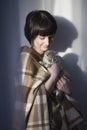 Happy Woman Holding Kitten Against Wall