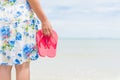 Happy woman holding pink flip flop on sandy beach Royalty Free Stock Photo