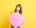 Woman  holding pink heart  on yellow background Royalty Free Stock Photo