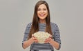Happy woman holding popcorn glass bowl