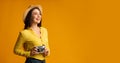 Happy Woman Holding Retro Camera Standing Over Yellow Studio Background Royalty Free Stock Photo