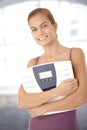 Happy woman holding scale in arms Royalty Free Stock Photo